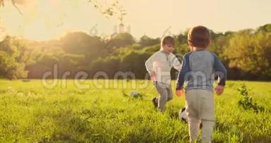 两个可爱的小孩子，一起<strong>踢</strong>足球，夏天。 孩子们在户外<strong>踢</strong>足球。