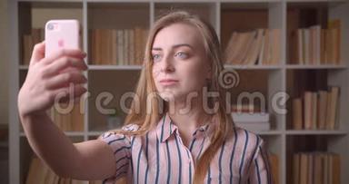 高校图书馆年轻漂亮的高加索女学生在电话里自拍的特写照片