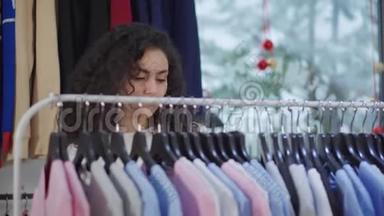 女顾客在销售时间在服装店货架上查看商品