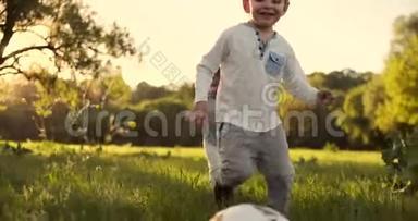 在慢镜头中，一个快乐的男孩带着足球在日落时分跑进了球场，梦想着踢职业足球