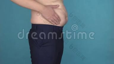 胖肚子的超重男人用慢节奏触摸和摇动他的腹部。 肥胖，无恩典的身体。 不管是什么人