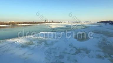 冬季城市冰冻河流的鸟瞰图。 鸟儿飞过冰河