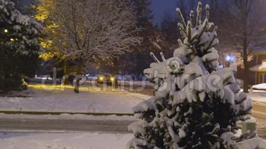 车灯在夜晚的冰路上，在小区的雪落在房子上，夜晚的冬天时间