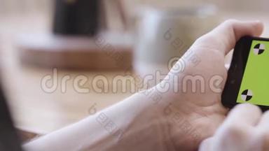 女人`手水平地拿着iPhone，她的手指在彩色钥匙绿色屏幕上滑动。 新的互联网概念