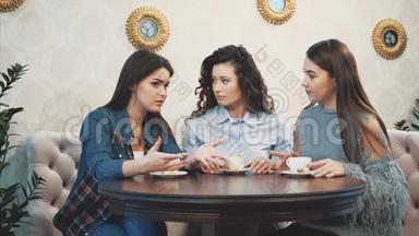 三个好的年轻女朋友在一家咖啡馆相遇。 同时喝卡布奇诺。 有长长的黑发。