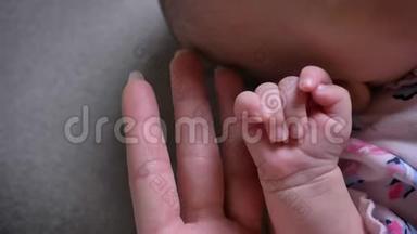特写镜头的妈妈和可爱的新生宝宝手相触..