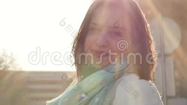 一位年轻女子站在风中的特写肖像。 春风吹着女孩`头发。 慢动作