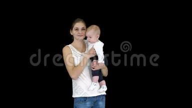 年轻的母亲抱着孩子时做一个注意的手势，阿尔法通道