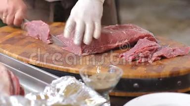 戴着白手套做饭，从一大块生肉中切下小块牛排。 优质猪肉粉嫩