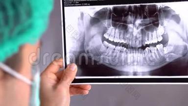牙科医生检查牙齿x光片。 在一个招待会上牙医。 牙医在平板电脑上给她X光