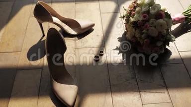 地板上有一束鲜花，<strong>金</strong>制的结婚戒指，阳光透过窗户<strong>洒</strong>下来，女人`鞋子，婚礼安排