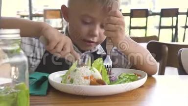 可爱的男孩和女孩在儿童餐厅吃食物。 小女孩和男孩在餐馆吃饭。 兄妹吃东西