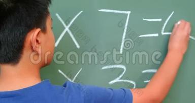 亚洲<strong>小学生</strong>在学校教室用黑板解决<strong>数学</strong>问题的后视图