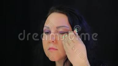 一个女人用一抹深紫色的阴影遮住她的眼睛