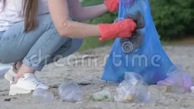 爱护自然生态，义务女孩戴着橡胶手套，在<strong>清理</strong>海滨时，把塑料<strong>垃圾</strong>收集在<strong>垃圾</strong>袋里