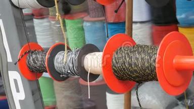 不同颜色的强力<strong>绳索</strong>缠绕在商店柜台上的特殊卷筒上