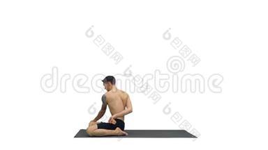 一个做<strong>瑜伽</strong>练习的年轻壮汉在白色背景上伸展帕德马萨纳腿。