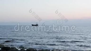 老锈船搁浅在岩石海岸。 美丽的海景，背景是大型货船。 货船搁浅在海上。 视图