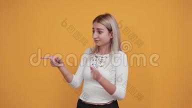 漂亮的女人在橙色的墙上做着怀疑的手势，看上去<strong>很困</strong>惑