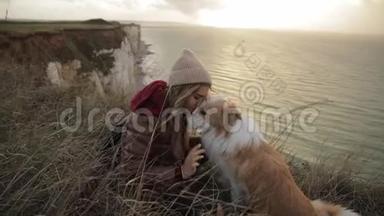 年轻女子抱着一只狗摸着她的头拥抱。 诺曼底悬崖上的<strong>好友</strong>