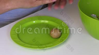 一个女人手里拿着炼乳卷着一团块饼干。 他把成品球放在盘子里。 蛋糕p的烹饪基础