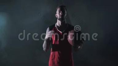 年轻英俊自信的篮球运动员的肖像，他用强壮的手拿着纹身玩球