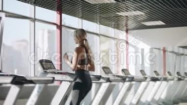 健身妇女在健身房跑步机上跑步。 有心脏训练的漂亮女孩。