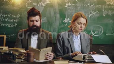 长胡子的教授和他的女助手在桌上工作，背景是板上的数学公式。 青年