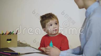 男孩和女人正在用白色背景上孤立的彩色铅笔画画和微笑。 心理治疗师观看