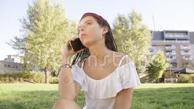 一个女孩坐在公园里，写信息，<strong>打电话</strong>。 黑发女人<strong>打电话</strong>，在公园里漫游，女孩<strong>打电话</strong>给她的朋友