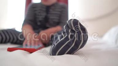 一个孩子点击智能手机的屏幕，坐在床上，慢动作