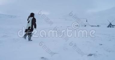 在北极行走的无人机中间，他穿着传统的衣服穿过雪地来到蒙古包