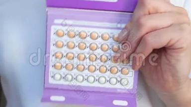 女孩特写显示一包口服激素避孕药丸。 计划生育，怀孕.. 女人`对的。