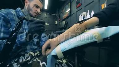 男艺术家正在他的工作室里做一个合成手臂上的纹身