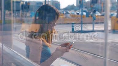 坐在公共汽车或地铁车站的年轻迷人的女人。 两次曝光。 女孩用她的手机。 输入信息