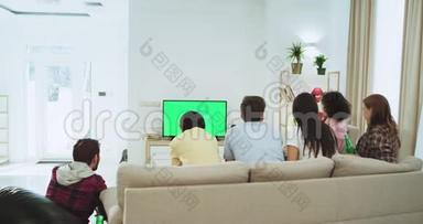 漂亮的朋友在一个<strong>大</strong>客厅里观看绿色<strong>屏</strong>幕<strong>电视</strong>，观看足球赛，他们支持他们最好的足球