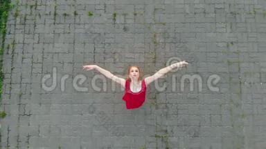 年轻漂亮的女芭蕾舞演员站在屋顶上，抬起头-微笑-跳舞