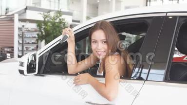 幸福的女司机在<strong>车展</strong>室的新车里拿着车钥匙