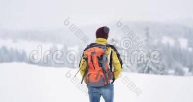 在雪林里散步的游客，带着所有的<strong>旅行用品</strong>，带着一个大橙色的袋子，他在中间<strong>旅行</strong>。
