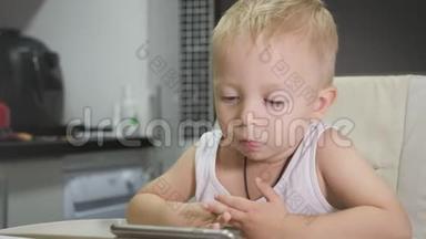 可爱的小男孩在家吃早餐时喝牛奶，同时在<strong>平板</strong>电脑上看<strong>卡通</strong>。 儿童和技术