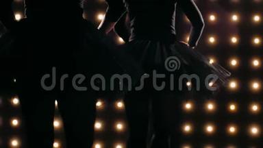 两个穿黑色<strong>芭蕾</strong>舞裙的<strong>芭蕾</strong>舞演员的剪影正在黑暗的工作室里跳<strong>芭蕾</strong>。