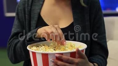 无法辨认的女人在电影院吃爆米花。