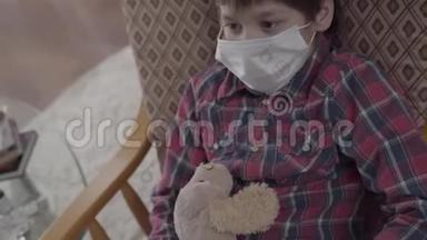 肖像<strong>小生</strong>病的男孩坐在扶手椅上，脸上戴着医疗面具，拿着玩具在家里。 不同的药丸