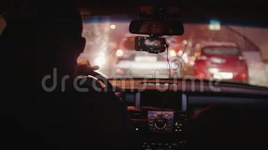 汽车在交通堵塞中行驶。 在城市繁忙的夜晚，在肮脏的挡风玻璃下