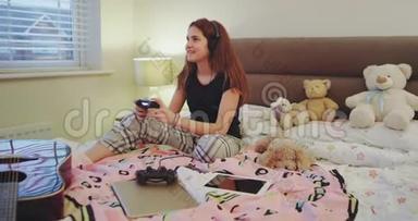在一个可爱的少年卧室里，年轻的女士在玩<strong>游戏站</strong>的<strong>游戏</strong>，她非常集中，微笑着。