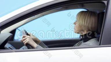 金发女人穿着休闲装，驾驶着绿色屏幕背景的汽车。 4.她正坐在车上喝着酒