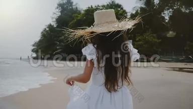<strong>镜头</strong>跟随快乐，无忧无虑，美丽<strong>的</strong>女孩，享受轻松<strong>的</strong>散步，沿着<strong>大气的</strong>海滩，戴着大草帽。