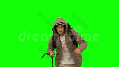 穿着外套和登山杖的人在绿色屏幕上奔跑
