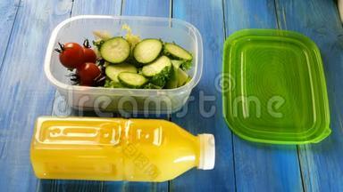人用手倒入食用油新鲜沙拉，黄瓜和樱桃西红柿在塑料午餐盒。