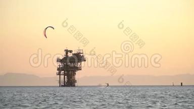 女人在海上风筝冲浪，靠近石油钻井平台，<strong>乘风破浪</strong>，埃及